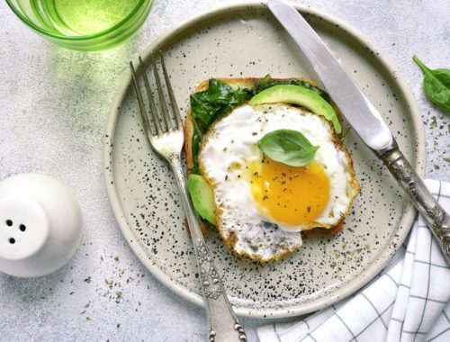 A plate with an egg and avocado on it