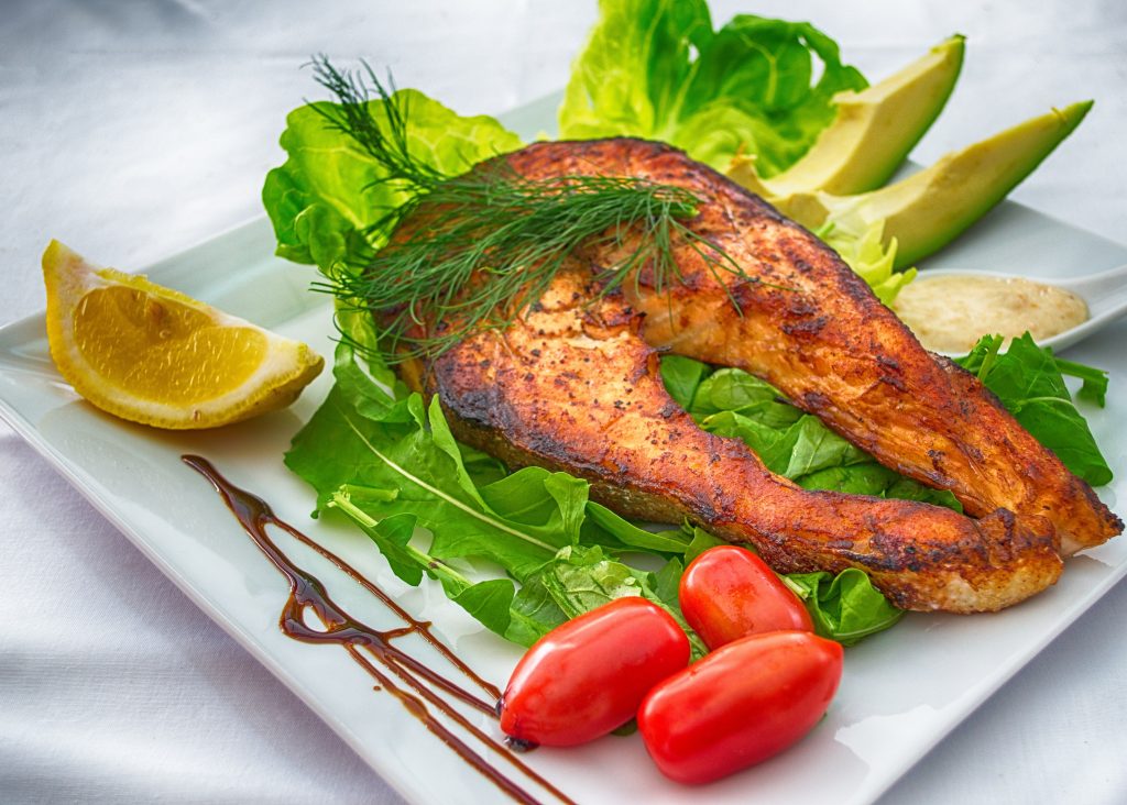 A plate of food with some vegetables and fish